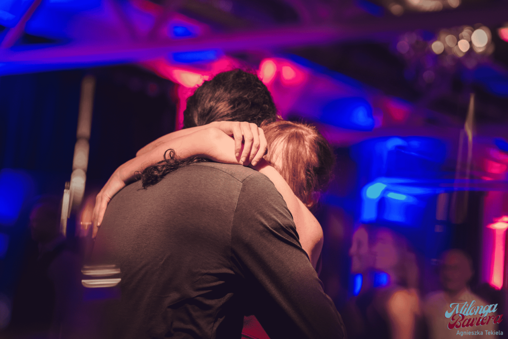 A dance couple hugging aftera tango tanda