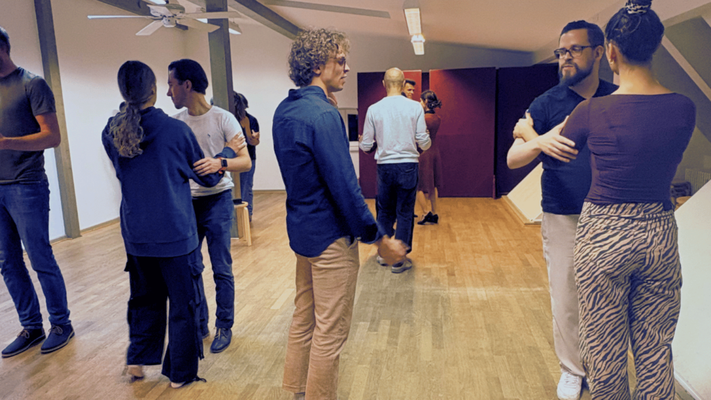Group tango lesson at Tango Flow, beginners dancing Argentine tango together in a friendly and supportive learning environment.