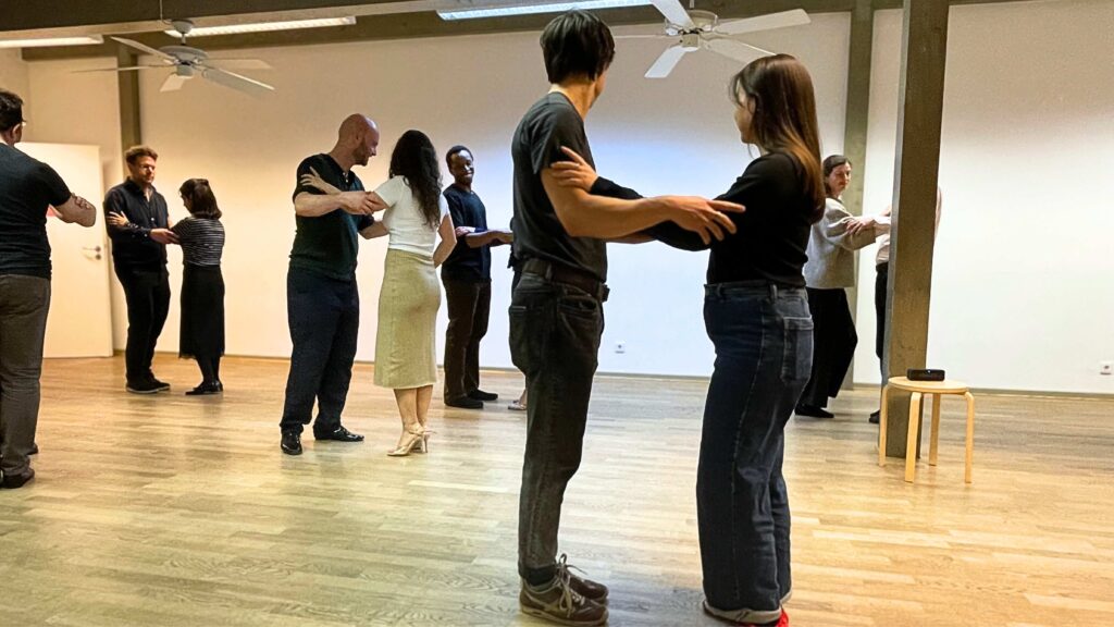 Beginner tango students practicing the baldosa as a first structure to organize movement.